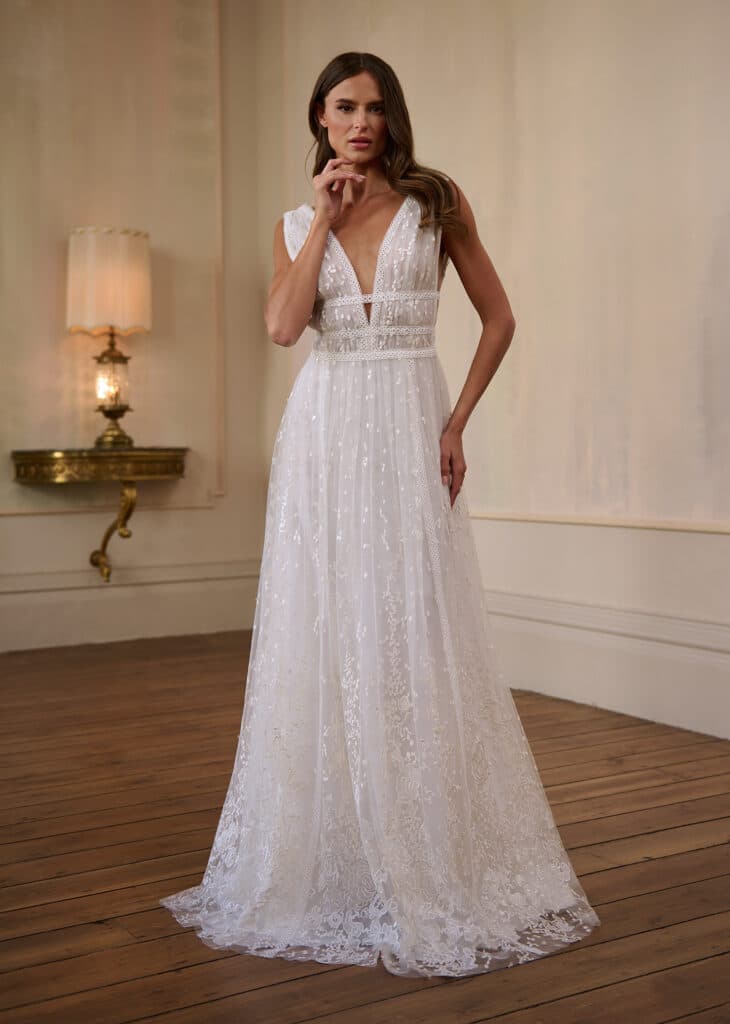 Step into ethereal elegance with this bohemian lace gown. This romantic A-line wedding dress is crafted from delicate embroidered lace and subtle sequin accents, shimmering gently with every step.